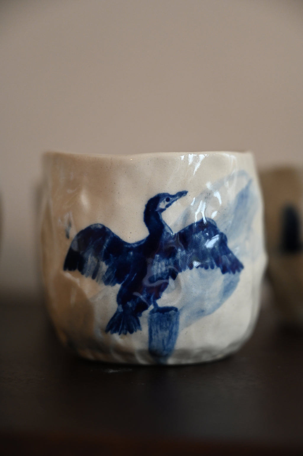 Mok met aalscholver op paal